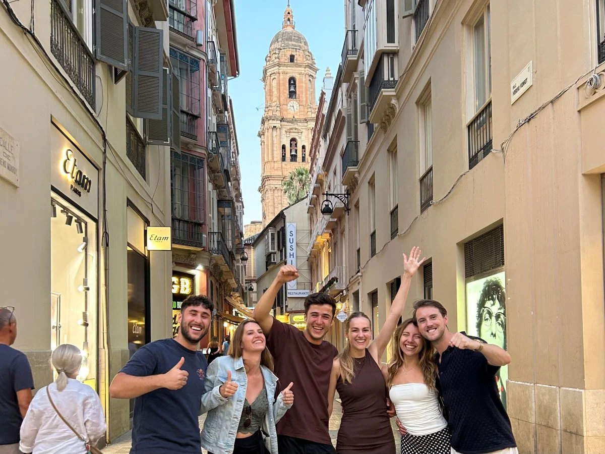 Private tour group and guide having fun in Calle Larios of Málaga city centre with the cathedral la manquita in the background