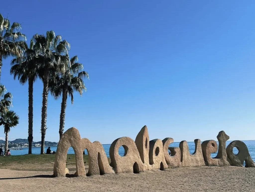 Sunbathers and palm trees along Malagueta Beach in Málaga city centre near the port