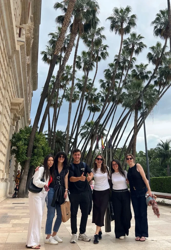 Private tour group with a licensed local tour guide between the museum and the botanic garden in Málaga old town with palm trees in the background