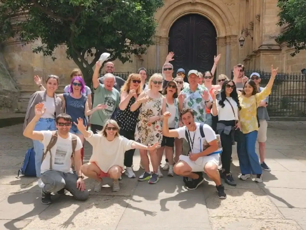Happy tourists in front of the cathedral la manquita in Malaga historic centre during a free walking tour