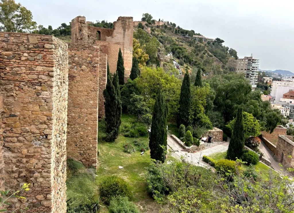 Views from the alcazaba of the castillo de gibralfaro with the moorish walls on the left and views of malaga city centre and port