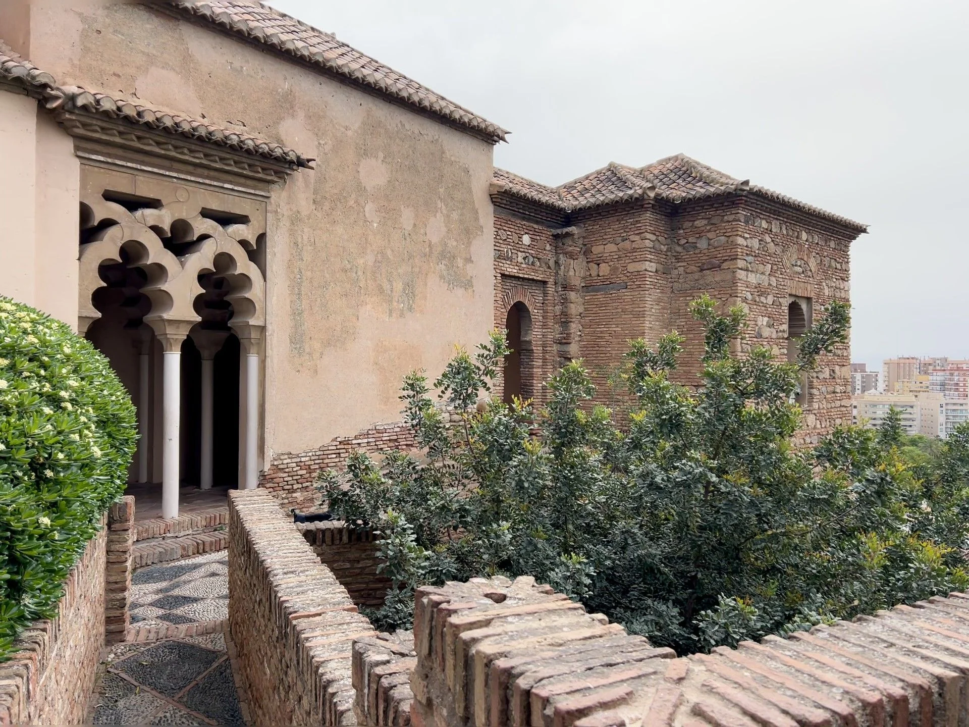 Palace inside of the alcazaba of malaga with views of the city centre and trees with a local
