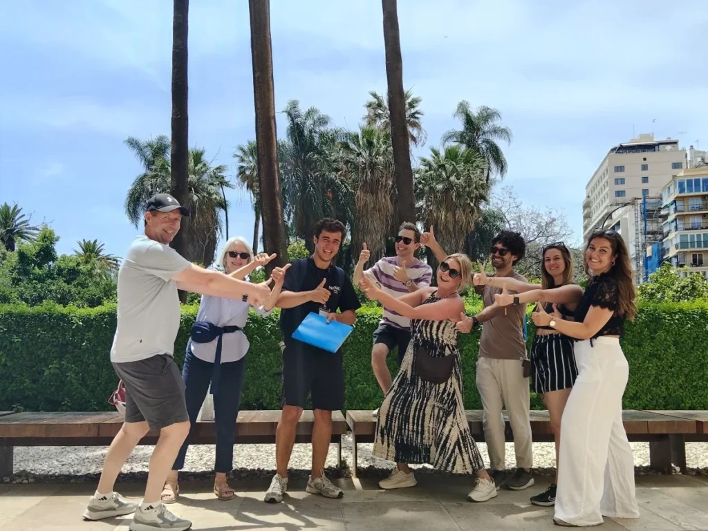 Free walking tour malaga group with the licensed local guide in front of museum de malaga with palm trees in the background