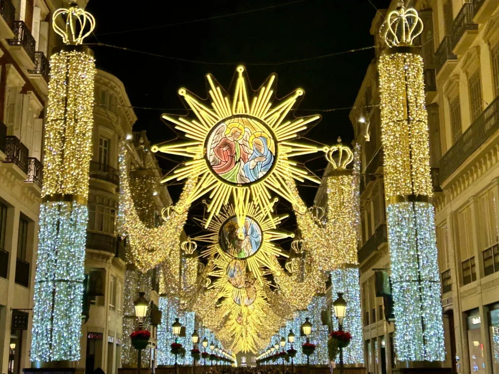Illuminated star-shaped Christmas lights over Calle Larios in Málaga during winter at night