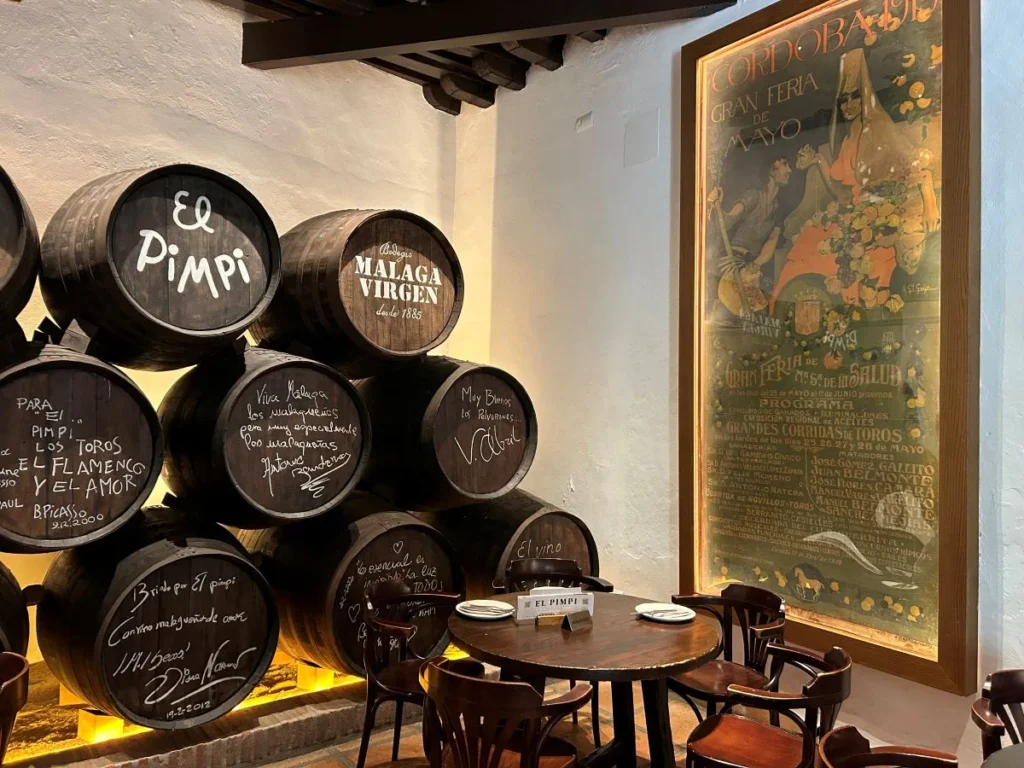 Traditional tapas spread with wine glasses in a local bar el pimpi in Málaga historic centre at night
