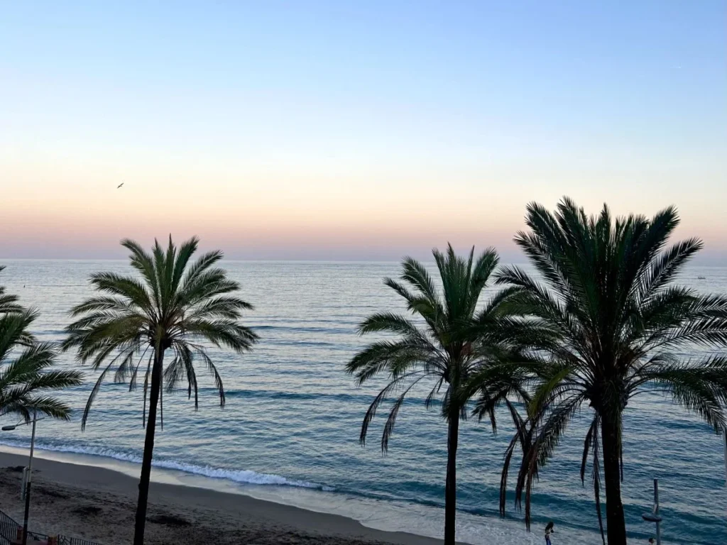 La Malagueta beach Málaga with calm Mediterranean water palm trees and chiringuito beach bars sunset