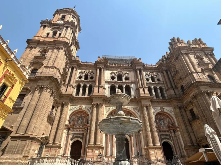 Málaga Cathedral La Manquita facade with fountain in front, showing the completed north tower and unfinished south tower
