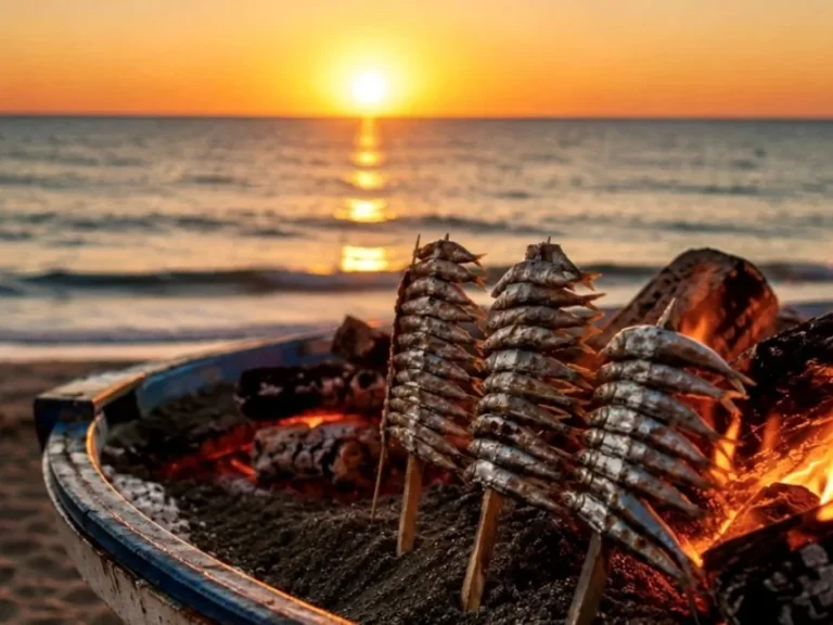 espetos sardines on cane skewers over an open fire grilling on the beach in Málaga during sunset typical spanish food